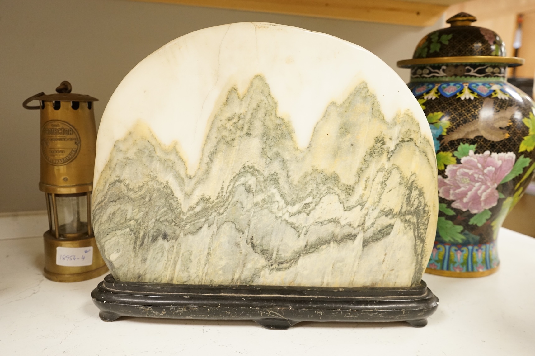 A Chinese dreamstone carving on stand, 38cm wide
